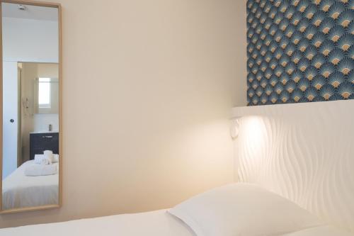 a bedroom with a mirror and a white bed at GAB HOUSE - Lyon Bron - Eurexpo City Living Stay in Bron