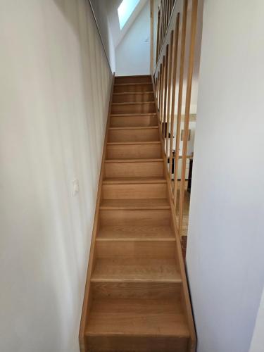 a stairwell in a building with wooden steps at Maison en brique calme, nature, confort in Notre-Dame-du-Hamel
