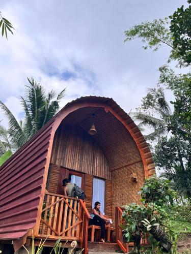 a person sitting in the window of a round house at Tetebatu flower in Tetebatu