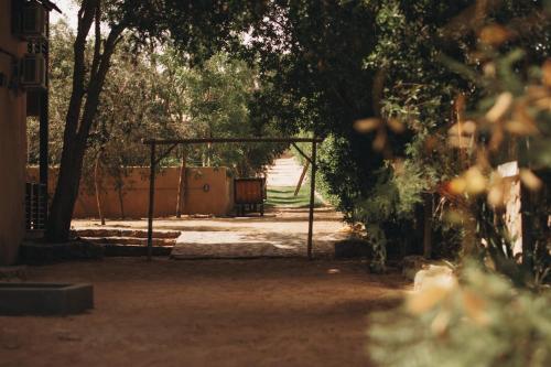 an open gate in a garden with a bench at The Wind Farm in Dahab