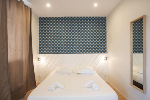 a room with a bed with two white towels at GAB HOUSE - Lyon Bron - Eurexpo City Living Stay in Bron