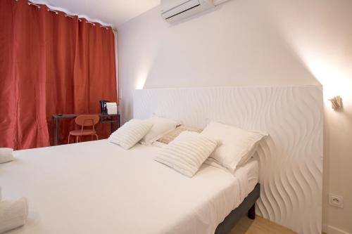 a bedroom with a white bed with two pillows at GAB HOUSE - Lyon Bron - Eurexpo City Living Stay in Bron