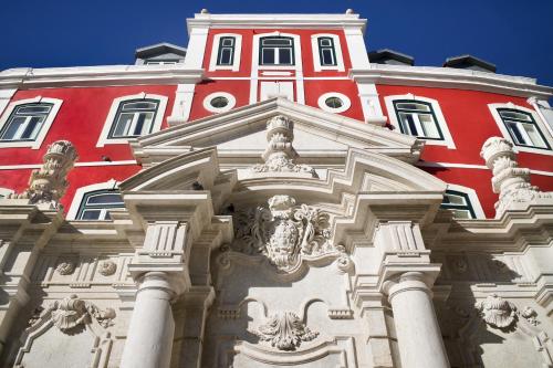 a red and white building with columns in front of it at Hermitage Castelo - Casa Chafariz in Lisbon
