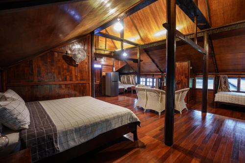 um quarto com uma cama em uma sala com paredes de madeira em Nagari by the Hills at N9 em Pantai