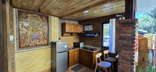 a kitchen with a refrigerator and a brick wall at Tutde Guest House in Bringkit