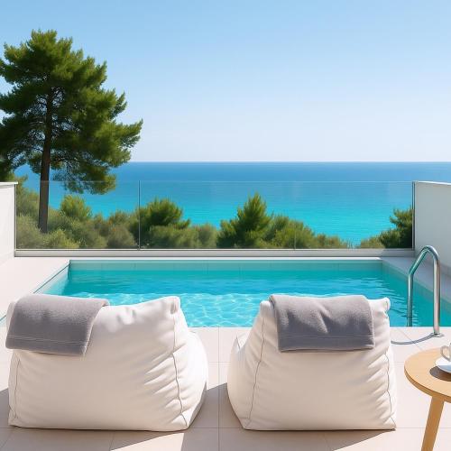 a swimming pool with two white chairs in front of it at Gloria Luxury Suites in Kallithea Halkidikis