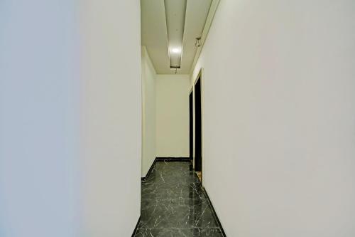 an empty corridor in a building with a white wall at FabHotel Million in Indore