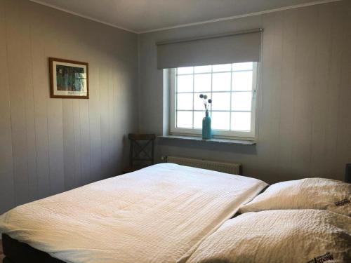 a bedroom with a bed and a window with a flower vase at Marbijes Appartementhaus in Cuxhaven