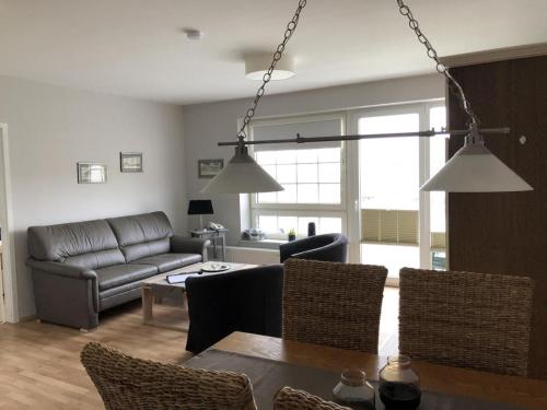 a living room with a couch and a table at Marbijes Appartementhaus in Cuxhaven