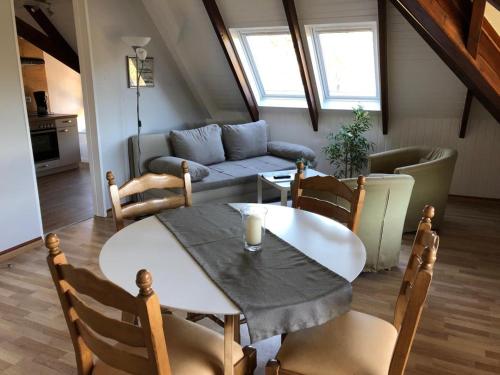 a living room with a table and a couch at Marbijes Appartementhaus in Cuxhaven