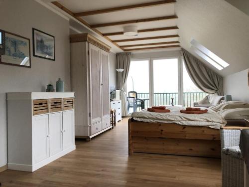 a bedroom with a large bed and a large window at Marbijes Appartementhaus in Cuxhaven
