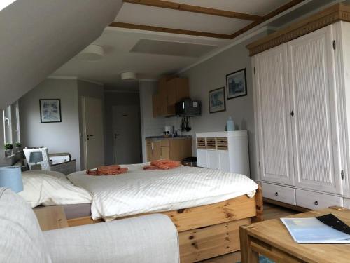 a bedroom with a large bed and a table at Marbijes Appartementhaus in Cuxhaven