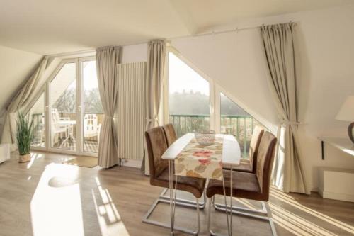 a dining room with a table and chairs and a large window at Marbijes Appartementhaus in Cuxhaven