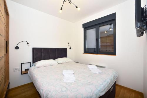 a bedroom with a large bed with two towels on it at Vila Mina in Zlatibor