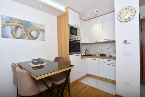 a kitchen with a table and a clock on the wall at Vila Mina in Zlatibor