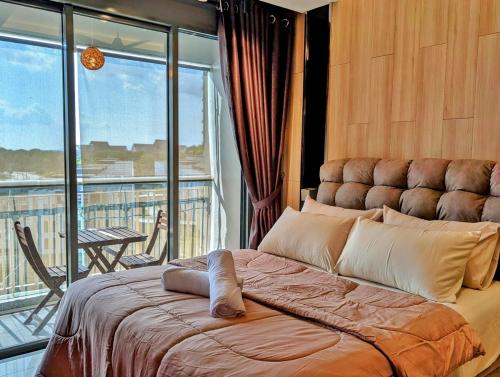 a bedroom with a large bed and a balcony at Family Friendly Designer Studio At Puteri Harbour in Iskandar Puteri