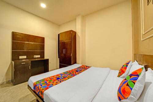 a bedroom with a bed with a colorful blanket at FabHotel Million in Indore