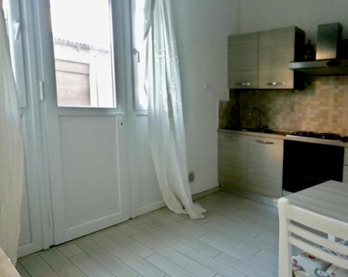 a kitchen with a door and a window and a table at Il Rifugio delle Valli in Comacchio