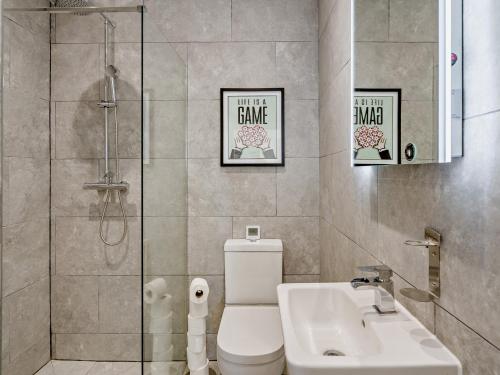 a bathroom with a toilet and a sink and a shower at 3 Bed in Anstruther 96111 in Pittenweem