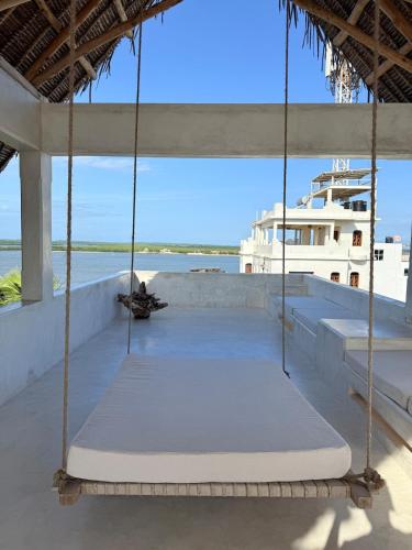 a swing on a roof with a boat in the water at Star House 4 in Shela