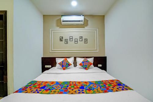 a bedroom with a bed with a colorful blanket at FabHotel Million in Indore