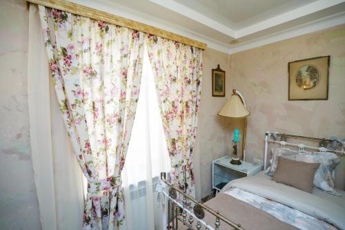 a bedroom with a bed and a window with flowers at The Victorian Hotel & Spa Room 1 in Yerevan