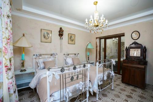 a bedroom with a bed and a chandelier at The Victorian Hotel & Spa Room 1 in Yerevan