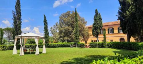 a garden with a gazebo in front of a building at La Palazzina in Val d'Orcia in Radicofani