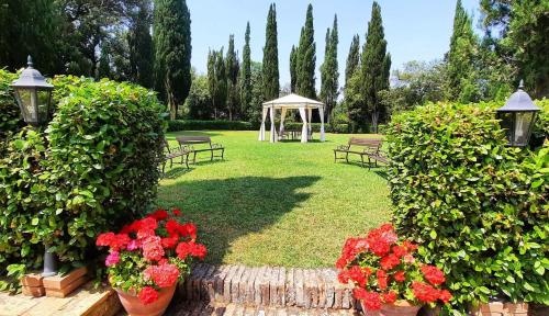 a garden with benches and a gazebo and flowers at La Palazzina in Val d'Orcia in Radicofani