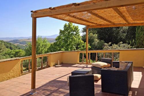a patio with chairs and a pergola with a view at La Palazzina in Val d'Orcia in Radicofani