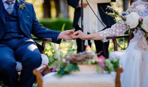 a bride and groom holding hands during their wedding ceremony at La Palazzina in Val d'Orcia in Radicofani