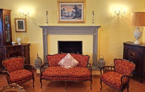 a living room with two chairs and a fireplace at La Palazzina in Val d'Orcia in Radicofani