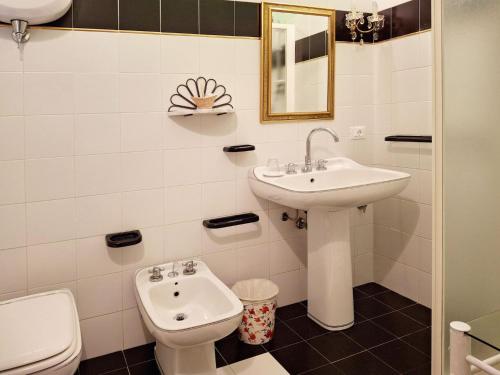 a white bathroom with a sink and a toilet at La Palazzina in Val d'Orcia in Radicofani