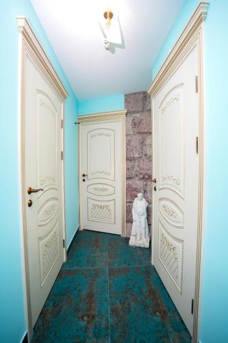 a hallway with two white doors and a stone wall at The Victorian Hotel & Spa Room 1 in Yerevan