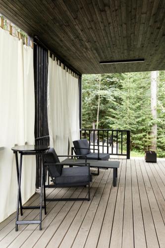 a room with a table and chairs on a deck at Moho Будинки для відпочинку in Bukovel