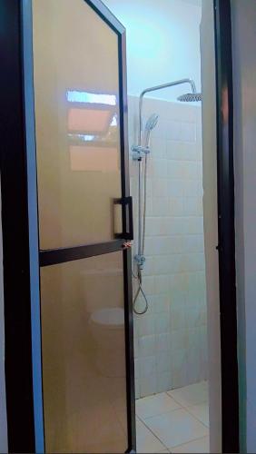 a shower with a glass door in a bathroom at Mihambos Apartments in Msambweni