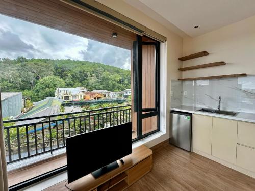 une cuisine avec une grande fenêtre offrant une vue dans l'établissement Núi Homestay Huế, à Hue