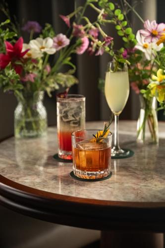 a table with two drinks and vases with flowers at Great Southern Killarney in Killarney