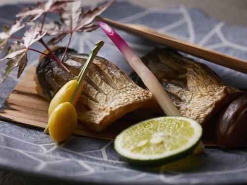 a plate of food with bread and a slice of lime at KAMENOI HOTEL Awajishima in Awaji
