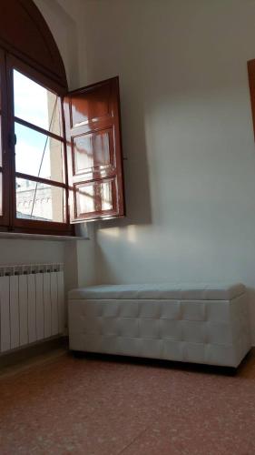an empty room with a large window and a couch at Vivi in una Torre Medioevale appartamento in Perugia