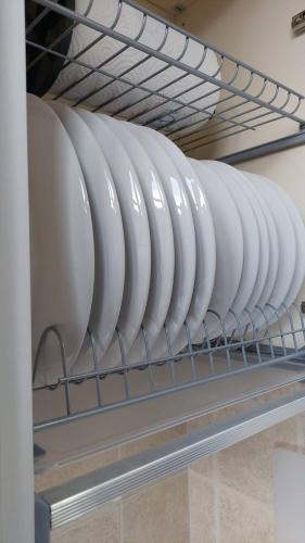 a row of white plates on a shelf at Vivi in una Torre Medioevale appartamento in Perugia