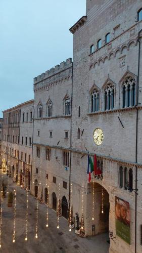 a large building with a clock on the side of it at Vivi in una Torre Medioevale appartamento in Perugia