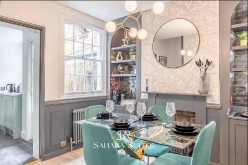 a dining room with a glass table and green chairs at Modern 2BR - Windsor Stays - Near Castle & Eton - Contractors & Families in Windsor