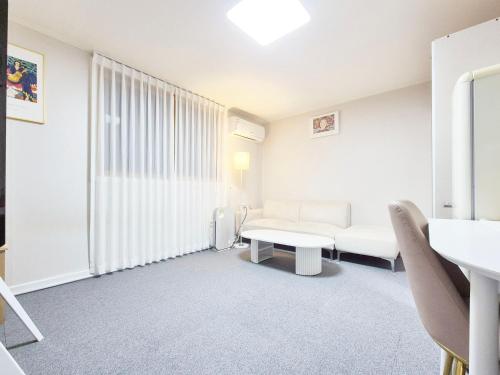 a white room with a couch and a table at Stay B in Sŭngch'ŏn-ni