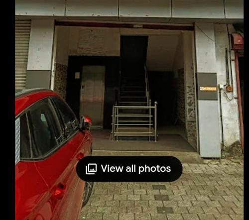 Un coche rojo aparcado delante de un edificio en M k residency, en Ernakulam
