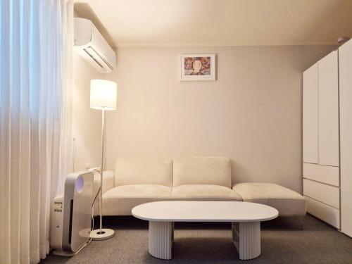 a living room with a couch and a table at Stay B in Sŭngch'ŏn-ni