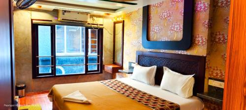 Una habitación de hotel con una cama y una ventana. en Karimeen Boathouse, en Alleppey