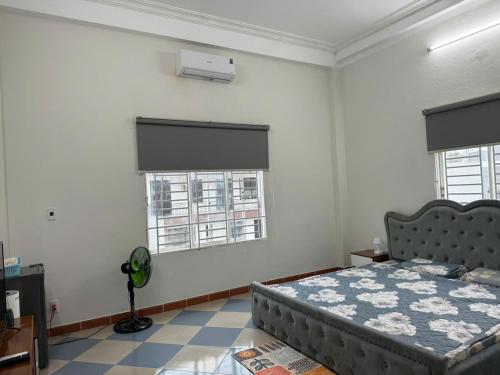 a bedroom with a bed and two windows at TH Homestay in Da Nang