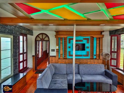 una sala de estar con un sofá y una mesa en Karimeen Boathouse, en Alleppey