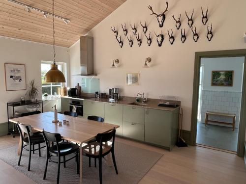 a kitchen with a wooden table and chairs in a kitchen at Guest wing at Ginkelösa Nygården in Linköping